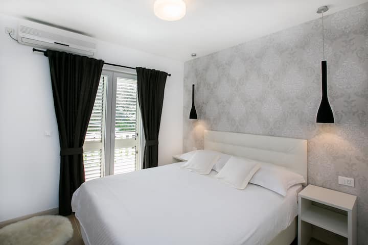 Dormitorio 2 con las puertas al balcón con vista a la colina.