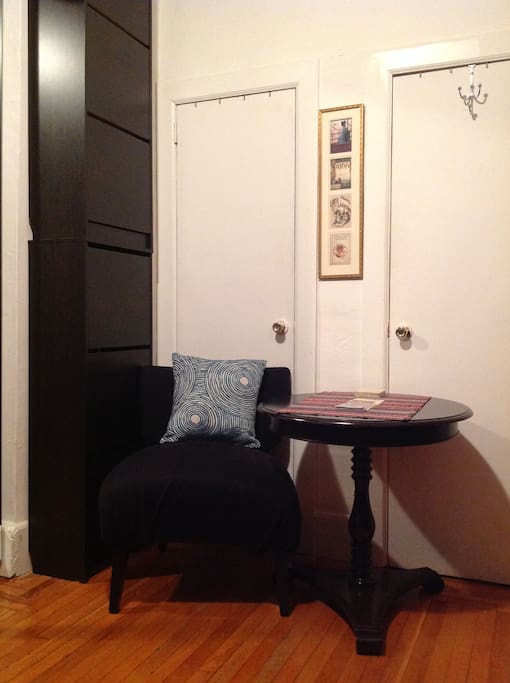 Table and large chair in bedroom (shoe racks).