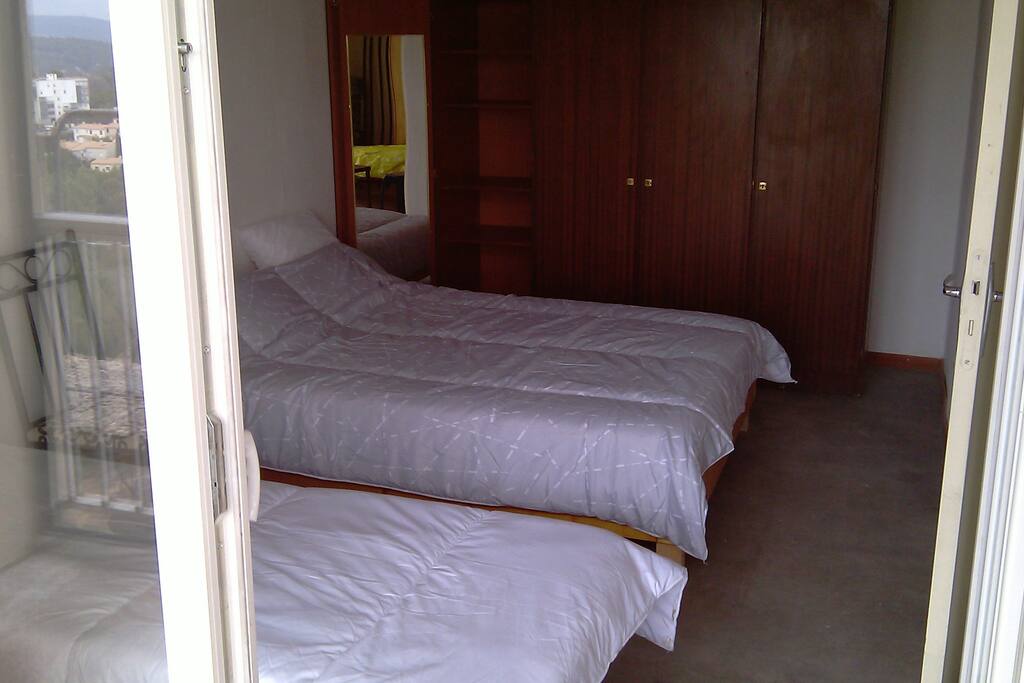 Chambre un lit double et un lit simple, table/travail, armoire, glace