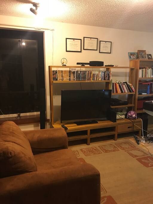 Estudio con pantalla, escritorio, cama, sillón, terraza