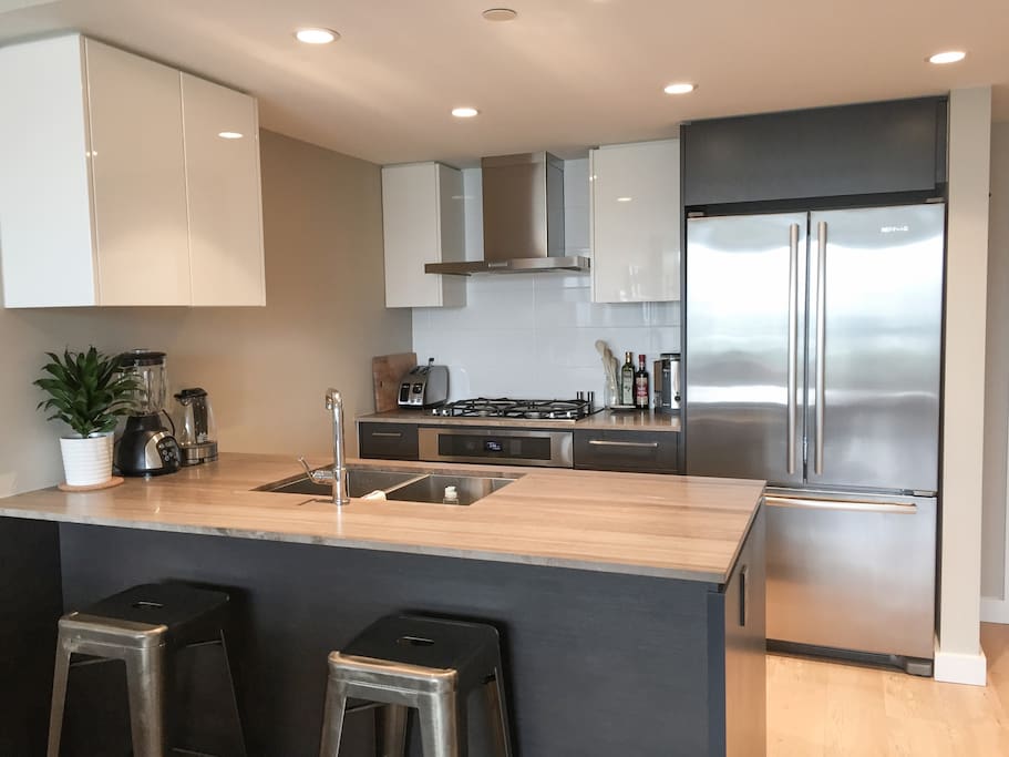 Clean kitchen, large fridge, sink, gas stove, dishwasher, microwave and toaster.