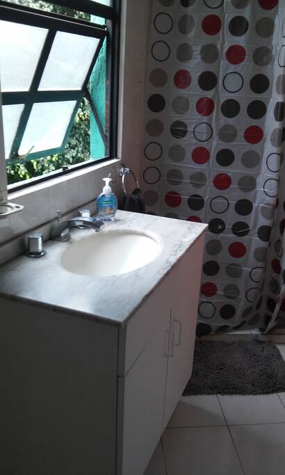 Baño iluminado natural con regadera y agua caliente, compartido con otra recamara