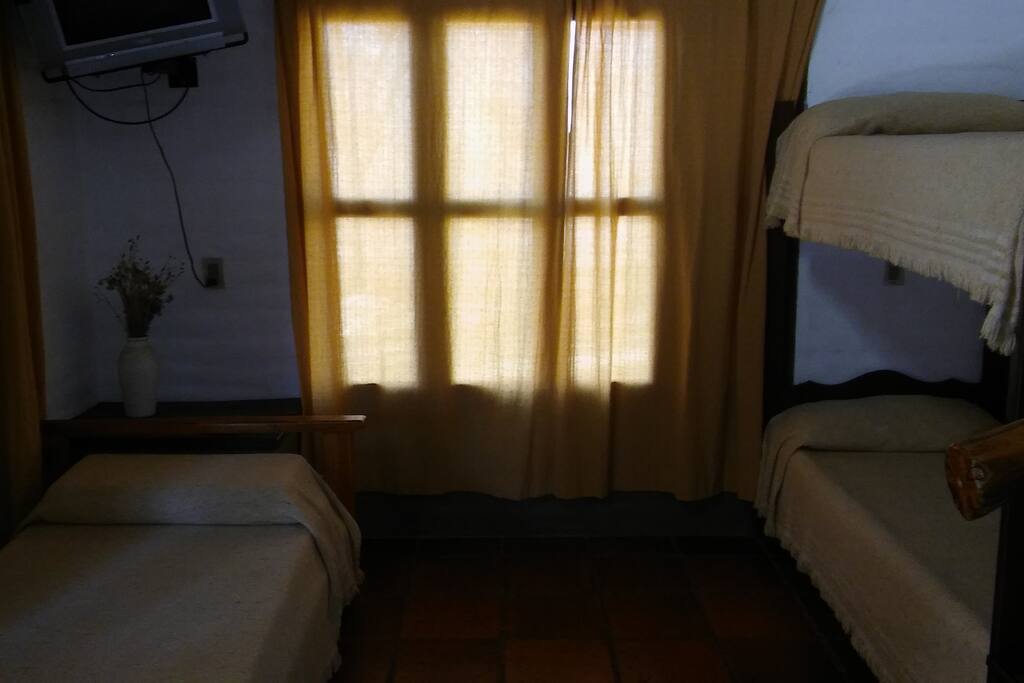 la cama simple y cucheta en el estar