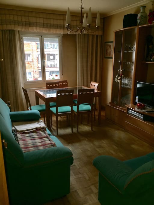 Salón con mesa comedor , sofás para 4 personas y televisión.