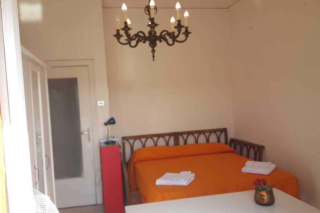 letto matrimoniale, due armadi, libreria e scrivania. stanza con balcone