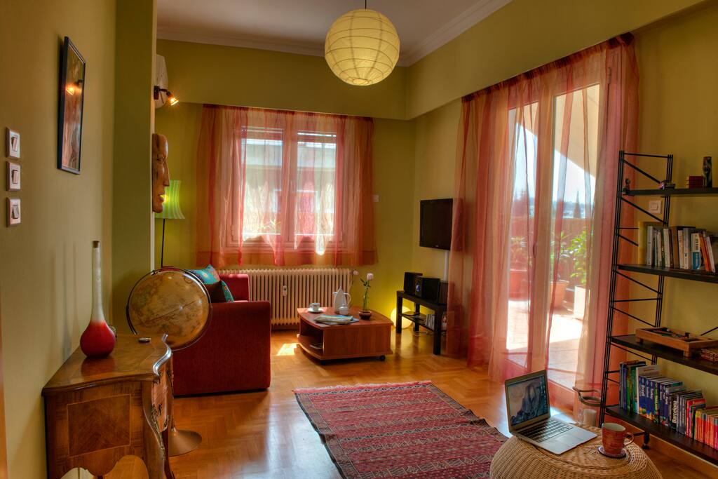 Spacious living room with ample natural light, sofa, Hi-Fi, DVD player, 32" flat screen TV and books.