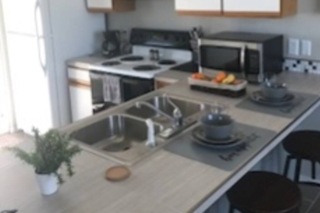 Fully furnished kitchen with countertop bar and stools