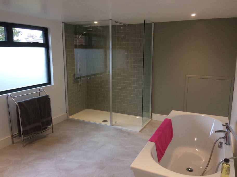 Separate loft bathroom with free standing bath and double shower.