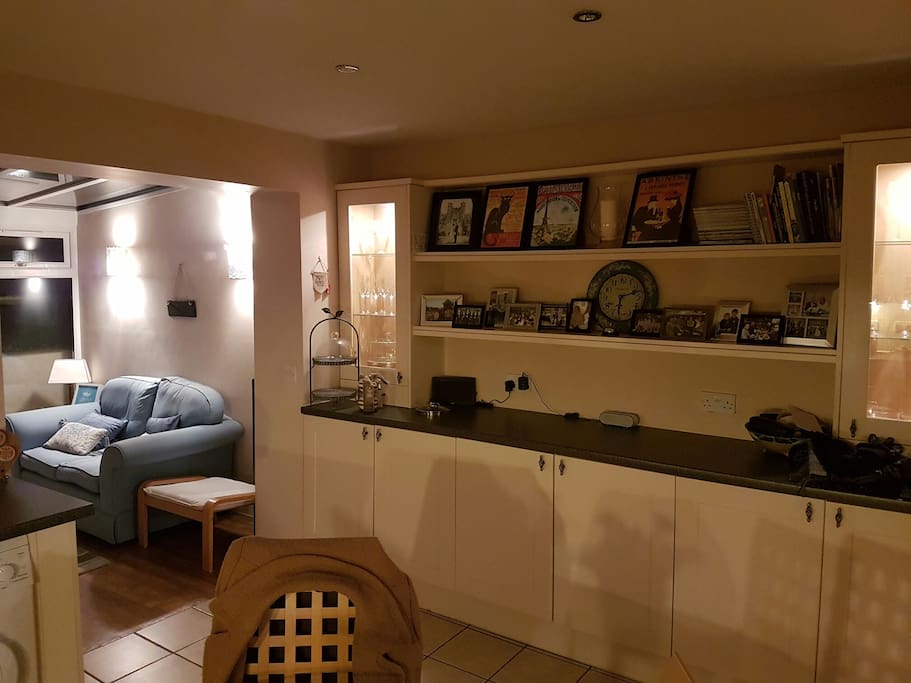 Kitchen with table and chairs for four people, and access to small conservatory seating four people