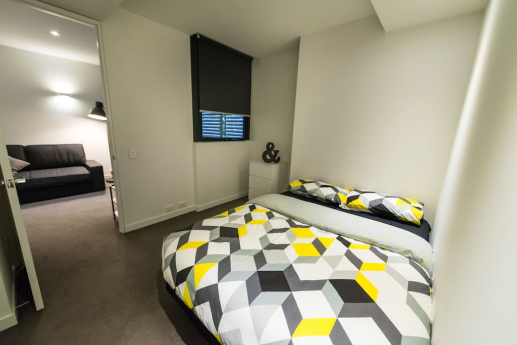 A bedroom with a queen sized bed & plush pillows.