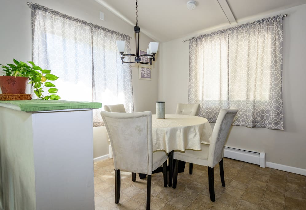 Dining area - behind the a four person dining table are four bar stools