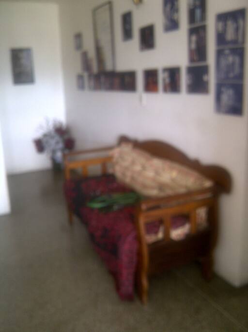 Parte de la sala, sofá, pasillo que da a la puerta de entrada al apartamento.