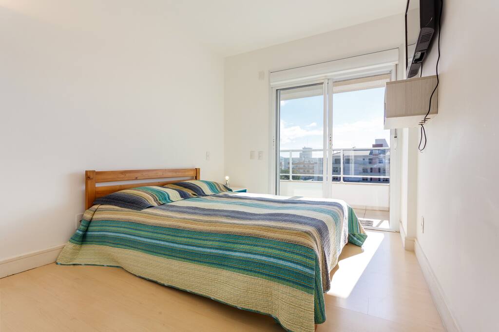 Suite com cama de casal, tv a cabo, ar condicionado e sacada com vista do mar.