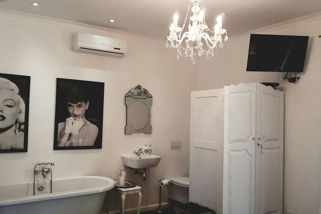 Bedroom 2 has 2single beds or can be a kingsize a bed, aircondioning, TV with all DSTV channels , and en-suite/ open plan bathroom with basin, toilet and Victorian style bath. The bedroom also has its own patio looking out onto the front garden.