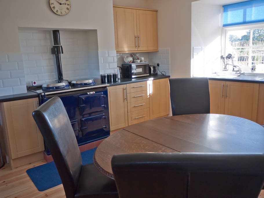 Dining kitchen with Aga, microwave, and dining table to easily seat 6 persons.