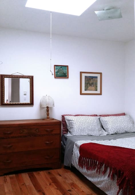 Room with a sunlight and a comfy bed which sleeps two. Dresser and hanging rack for your clothing.