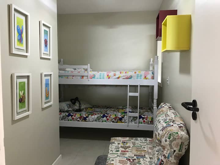 חדר שינה עם מיטת קומותיים ומאוורר תקרה