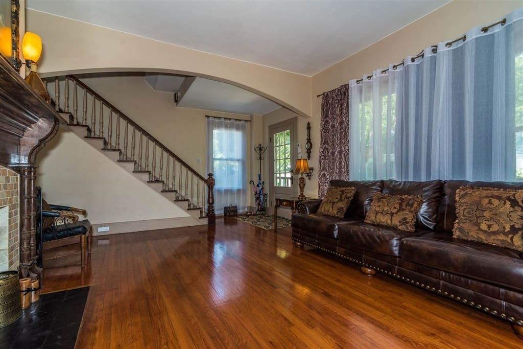 Standing in the formal living room, the honey glow of the original heart pine floor points you to the beauty of the intricately designed 19th century chocolate fireplace mantle. To your right is the original staircase.