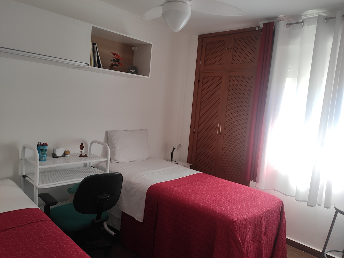 Habitación con 2 camas individuales y muebles con silla ergonómica, para computadora 