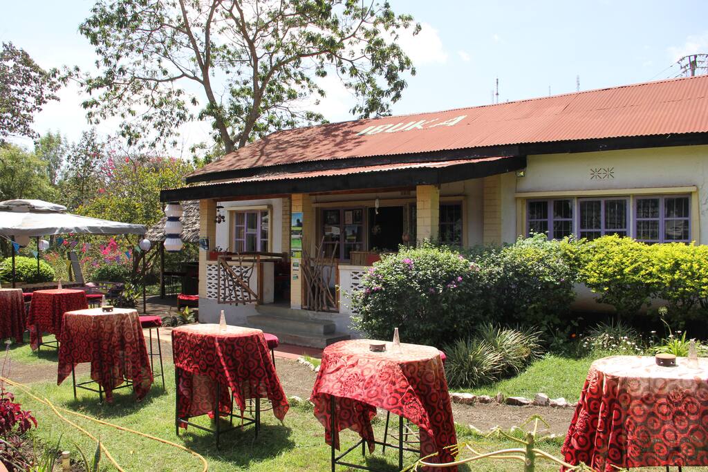 The house is in the garden of a dance centre with tables and chairs.
