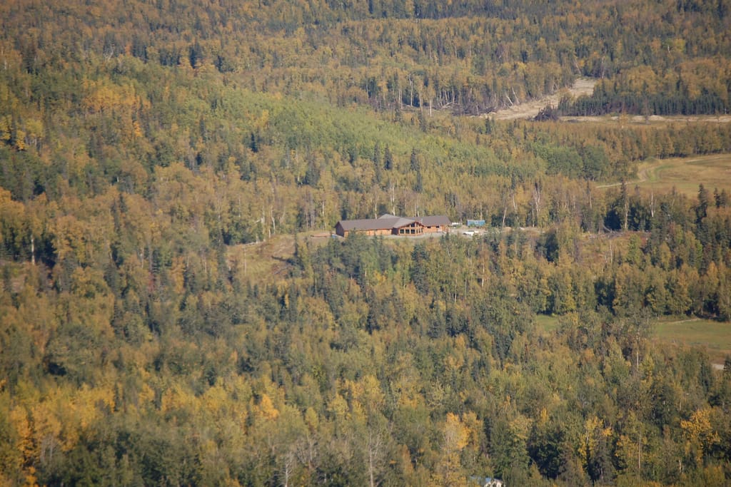 Aerial shot of Log Home on hill surrounded by 70 acres
