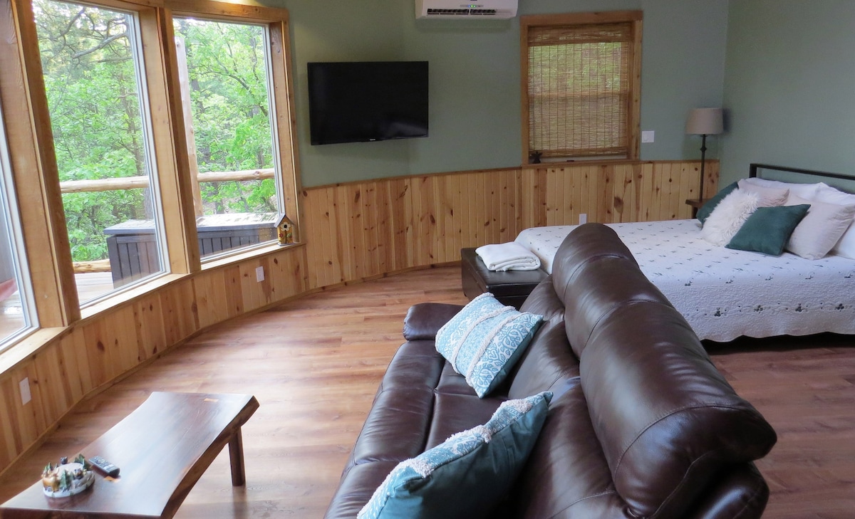 Open living room and bedroom with views out 5 large plate glass windows.