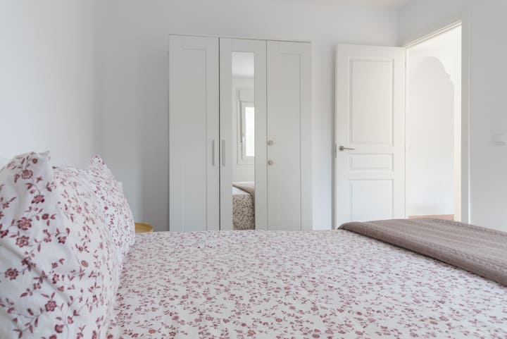 Основна спалня с огледален килер и две нощни шкафчета.