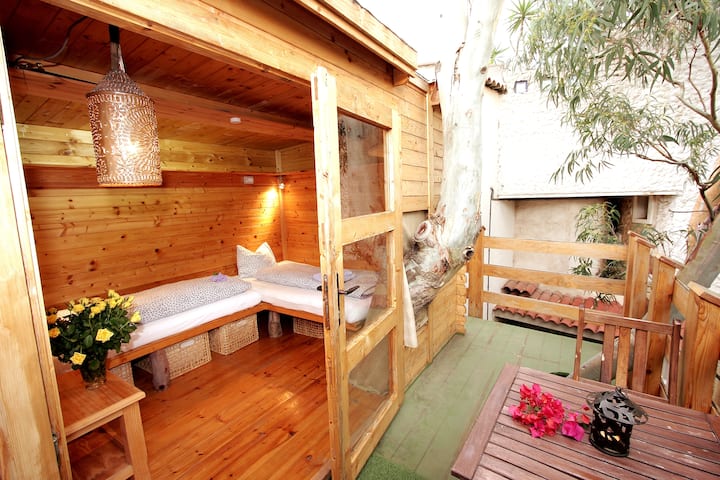 Blick auf das Baumhaus zum Schlafzimmer und gemütlicher Balkon vor einem Zimmer.