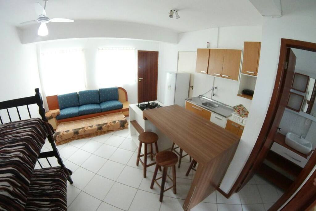 O apartamento conta com uma cozinha com utensilios básicos, banquetas para 5 pessoas, sofá.