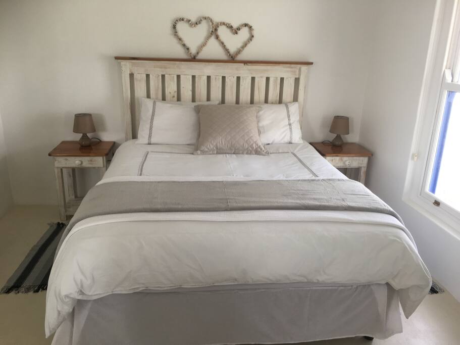 Comfortable queen size bed with crisp white linen