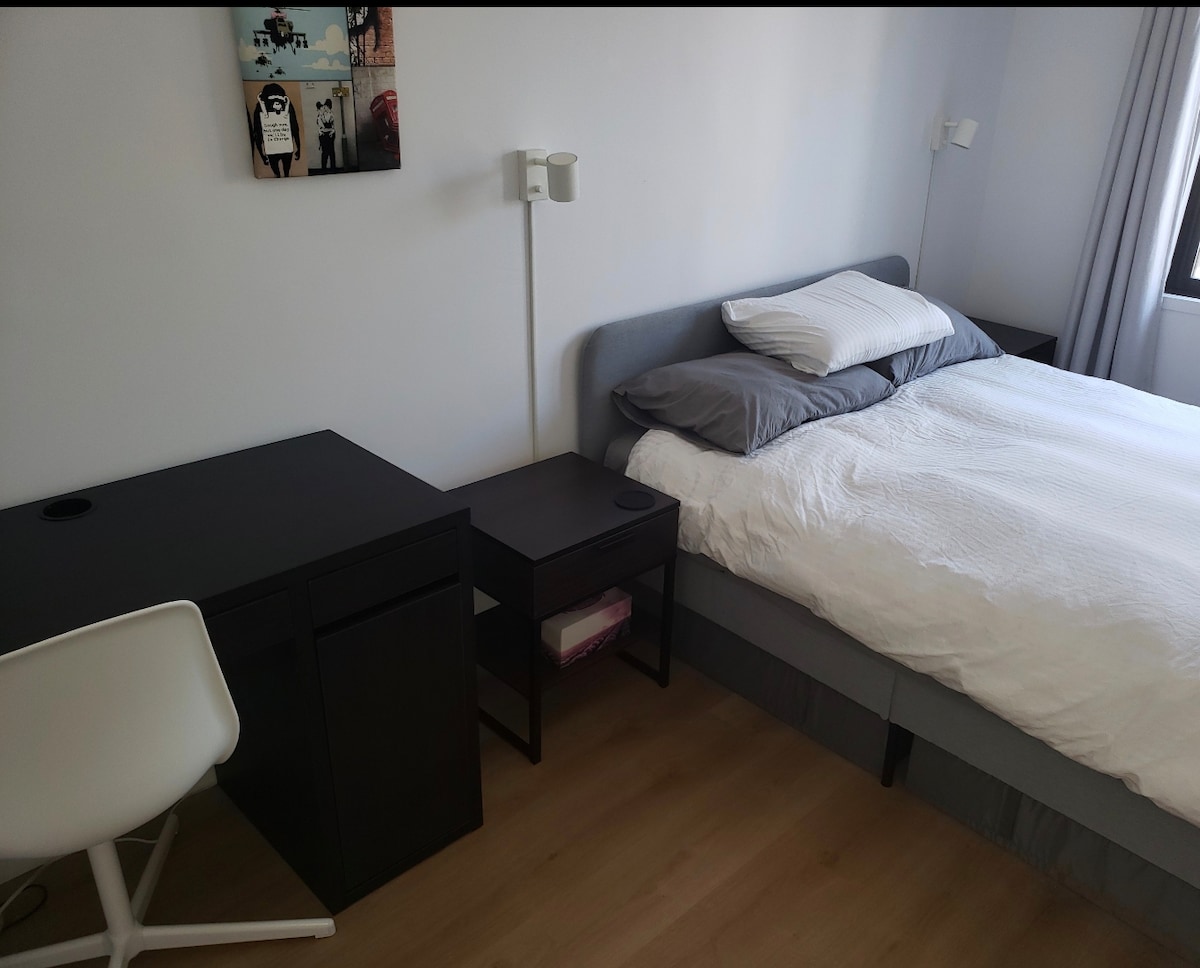 Spavaća soba 2, uključujući bračni krevet, dva noćna ormarića, radni stol i ormar.