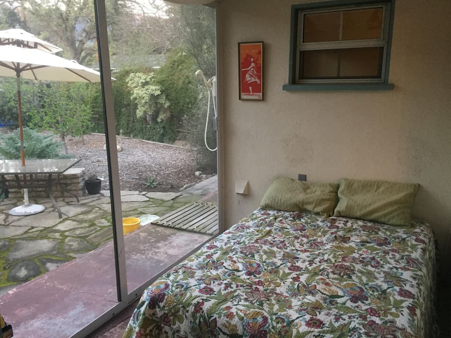 The guest room: a double bed with screen doors to the backyard
