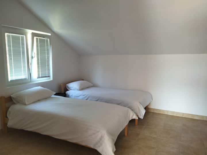 Единична стая с две единични легла, гардероб и самостоятелна тоалетна и мивка.