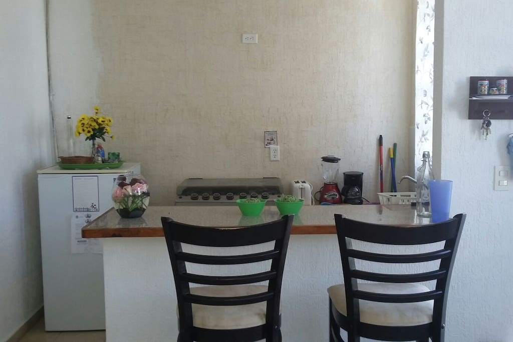 kitchen with fridge, stove, blender, coffe maker, dishes, glasses, and all you need