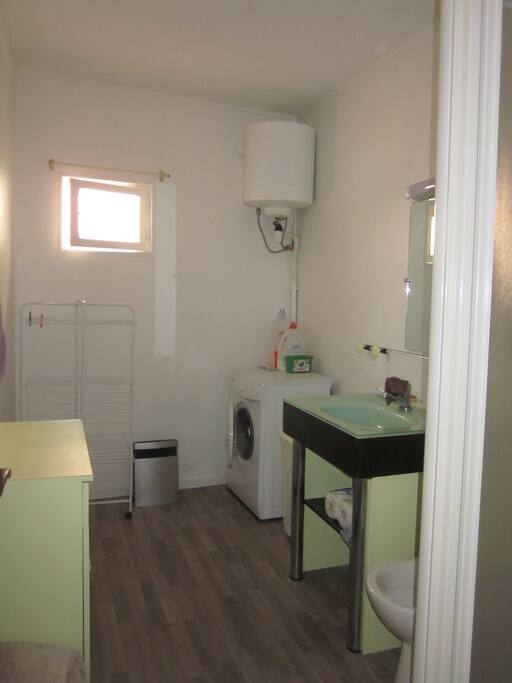 Une grande sdb avec machine a laver et douche