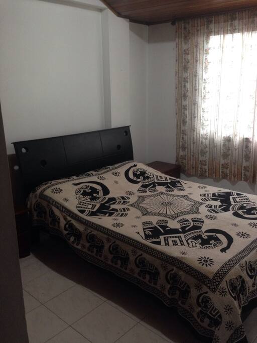 Habitación con TV, Netflix, internet, cama doble para pareja, con sus nocheros, y una ventana.