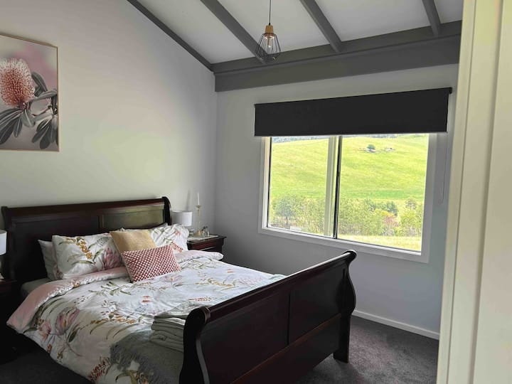 Habitación principal Sutto 's Hutto, que ofrece una cama tamaño queen, un espacio amplio y un ambiente romántico, donde la comodidad acogedora se encuentra con la serenidad íntima, creando el refugio perfecto para el amor y la relajación.