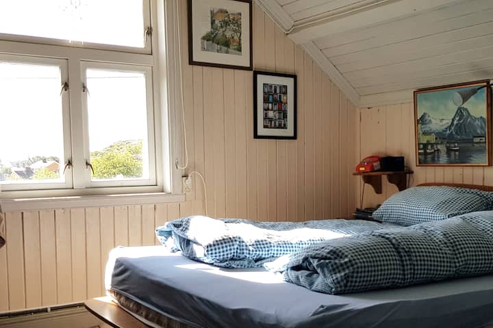 Hovesoverom med dobbelseng og utsikt mot fjell og fyret