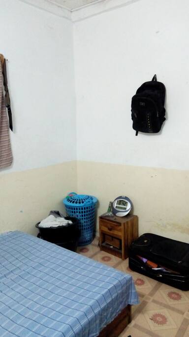 2ème angle de la chambre avec un bac panier pour les habits sales et 2 bassines noirs pour ranger ses habits et autres.