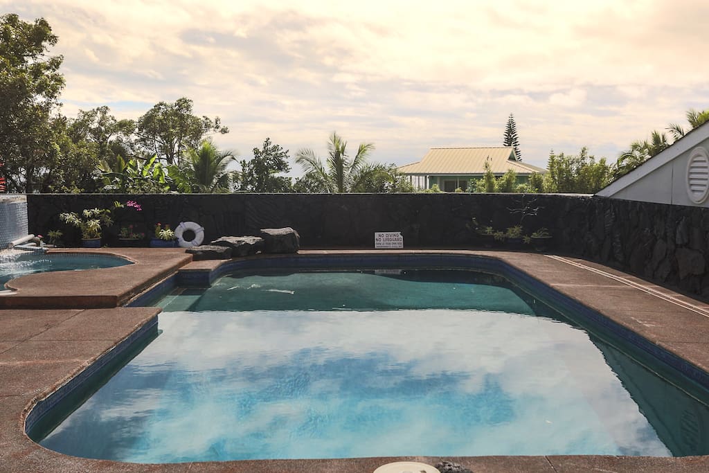 Spacious pool and hot tub area with ocean views, surrounded by lush tropical landscaping, and great privacy.