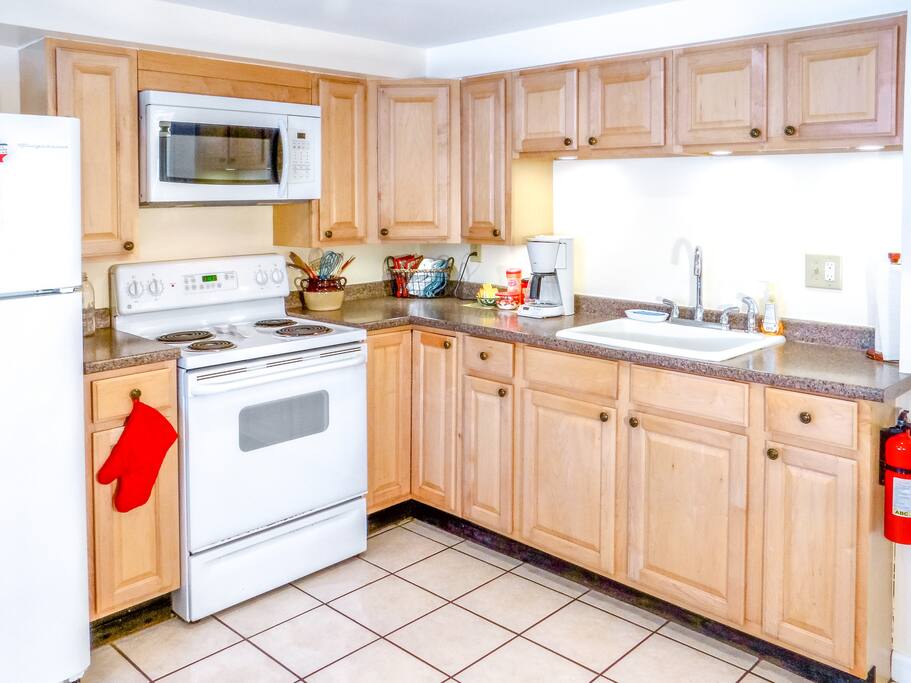 Bright full kitchen with microwave and coffee maker.