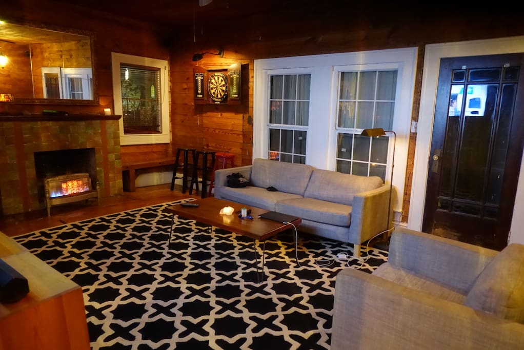 Large living space with sofa, fireplace, darts, 50" TV