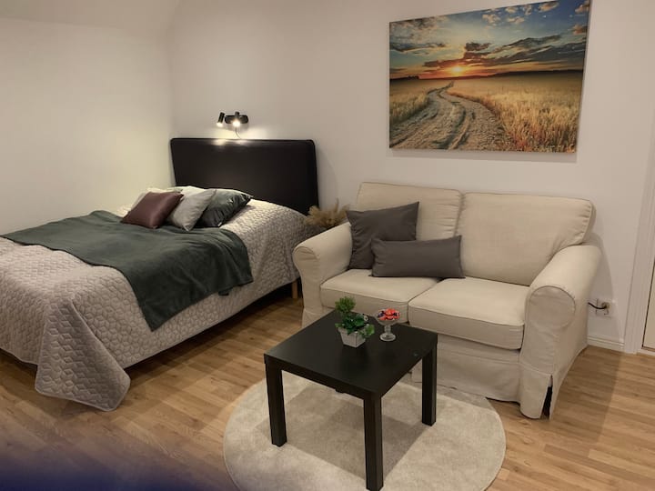 Kitanda maradufu kilicho na kochi karibu.