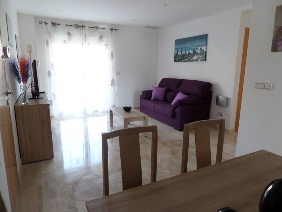 Salón amplio y con acceso a la terraza. Dispone de sofá grande, Tv, mesa comedor para 6 personas.