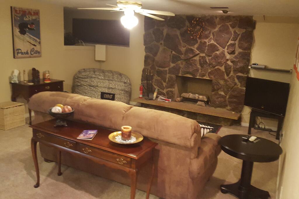 Comfortable sofa that folds out to a queen bed and a lovesac in front of the gas fireplace.