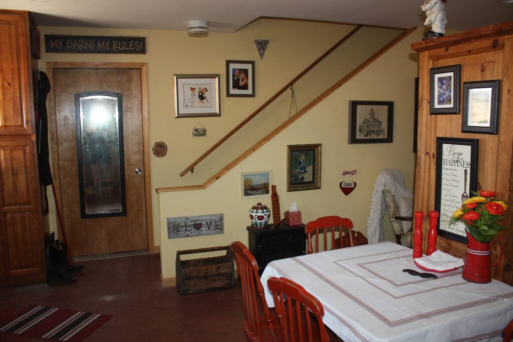 View of kitchen dining space and stairs to loft area. Additional patio table for outdoor use is available to guests as well.