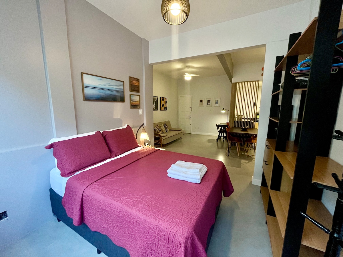 Стая със стандартно двойно легло, отворен килер, закачалка за дрехи и смарт телевизор.