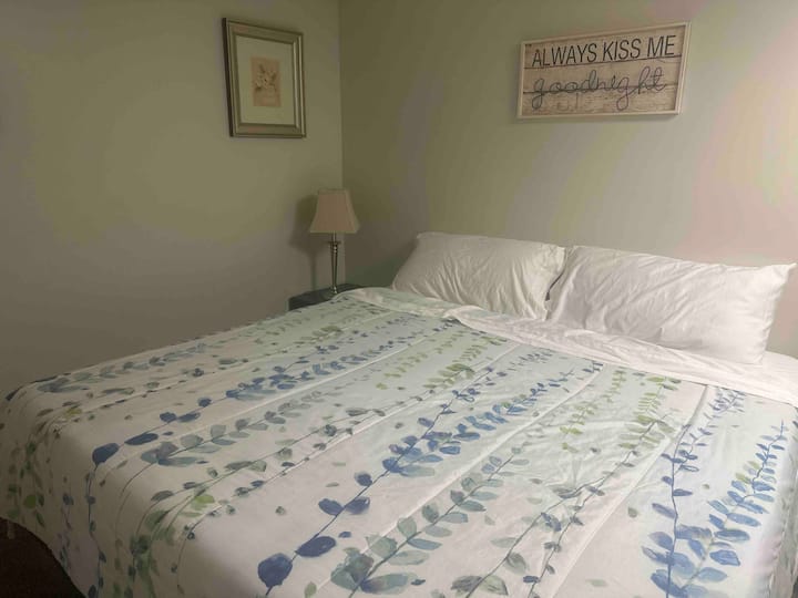 El dormitorio tamaño king de la planta baja tiene una mesa auxiliar con lámpara.