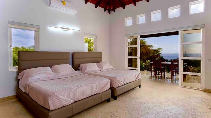 Segundo dormitorio con baño privado/ducha de efecto lluvia, terraza envolvente, vistas al mar en frente, balcón grande, mesa/ sillas al aire libre
TV de 60pulgadas, techos de bambú de 15 pies,armario, cocina americana/encimera de inducción, fregadero/refrigerador, 2 camas tamaño queen con colchón ortopédico.