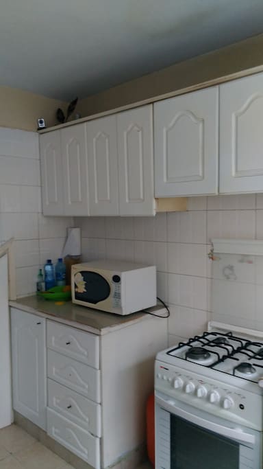 Kitchen equipped with microwave,cooker,sandwich maker,kettle ,blender,rice maker and fridge.
